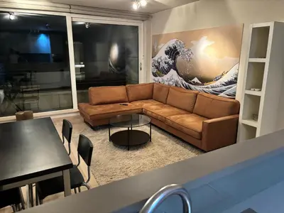 a living room with a couch and a painting of a wave at Comfortable Two bedroom Apartment in City Center in Brussels
