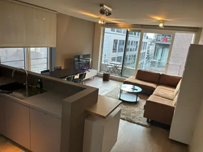 a kitchen and living room with a couch and a table at Comfortable Two bedroom Apartment in City Center in Brussels