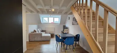 a living room with a staircase and a table and chairs at Blu shell house in Brussels
