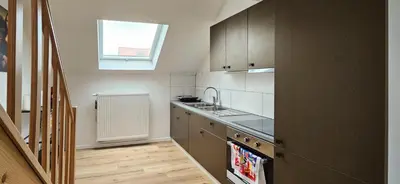 a kitchen with white cabinets and a sink and a window at Blu shell house in Brussels