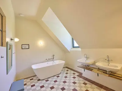 a bathroom with two sinks and a bath tub at Villa Lactea in Schilde