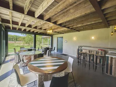 a patio with tables and chairs and a bar at Villa Lactea in Schilde