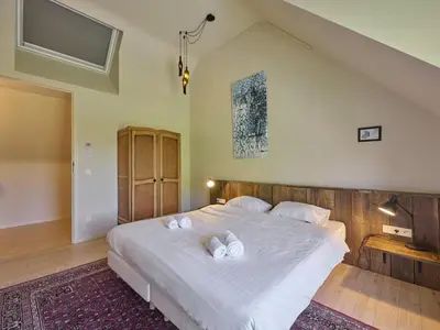 a bedroom with a large white bed with two pillows at Villa Lactea in Schilde