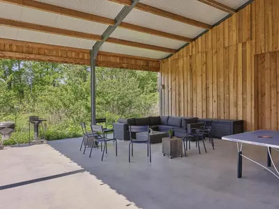 a patio with a couch and tables and chairs at Villa Lactea in Schilde
