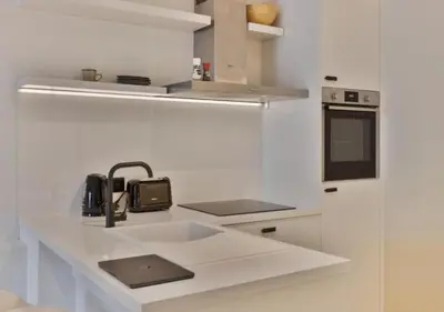 a white kitchen with a sink and a microwave at 1BR apartment by Central Station in Antwerp