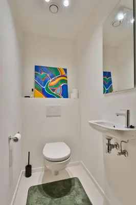 a white bathroom with a toilet and a sink at 1BR apartment by Central Station in Antwerp
