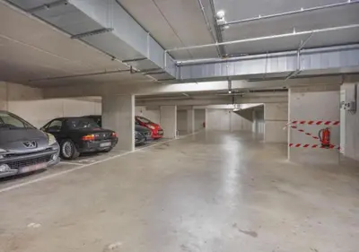 a large parking garage with cars parked in it at 1BR apartment by Central Station in Antwerp