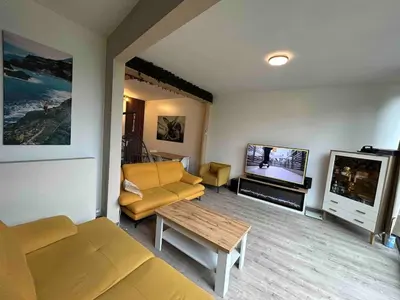 a living room with a couch and a tv at SiSEL HOUSE avaible with garden for 6 or more people! in Temse