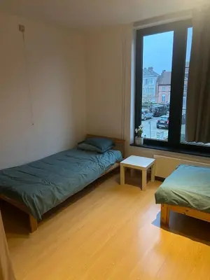 a room with two beds and a window at SiSEL HOUSE avaible with garden for 6 or more people! in Temse