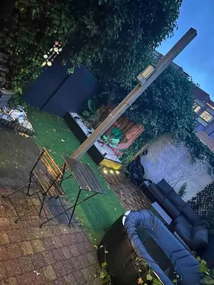 a wooden pole sitting on the ground next to a table and chairs at SiSEL HOUSE avaible with garden for 6 or more people! in Temse