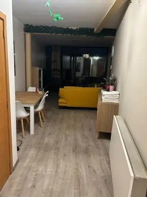 a living room with a yellow couch and a table at SiSEL HOUSE avaible with garden for 6 or more people! in Temse