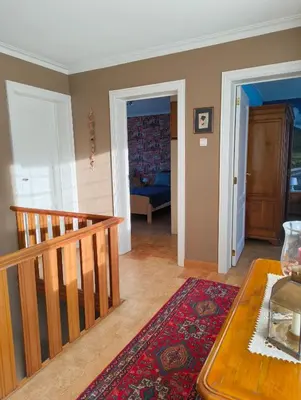 a living room with a staircase and a room with a table at Spelaan in Zottegem