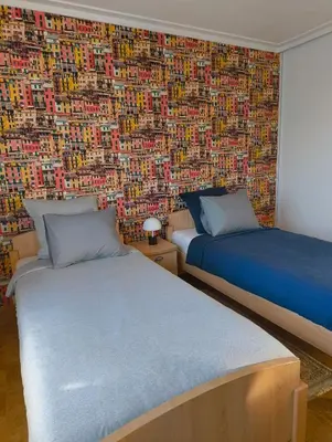 two beds in a room with a wall covered in photos at Spelaan in Zottegem