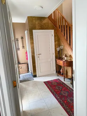 a hallway with a white door and a red rug at Spelaan in Zottegem