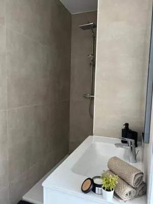 a bathroom with a white sink and a shower at Luxury Duplex near Expo 12 & ING Arena & Atomium in Wemmel