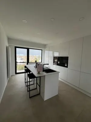 a kitchen with white cabinets and a table with chairs at Luxury Duplex near Expo 12 & ING Arena & Atomium in Wemmel