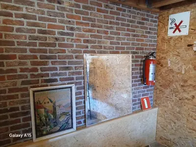 a brick wall with a fire hydrant and a picture at 't Spoor Berlaar in Berlaar