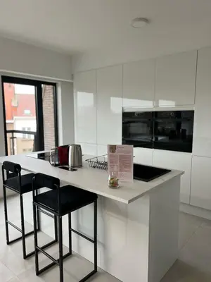 a kitchen with a counter with two stools and a counter top at Luxury Apartment near Expo 12 & ING Arena & Atomium in Wemmel