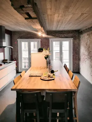 a large wooden table in a kitchen with chairs at Lux Loft in the heart of Historic Antwerp in Antwerp