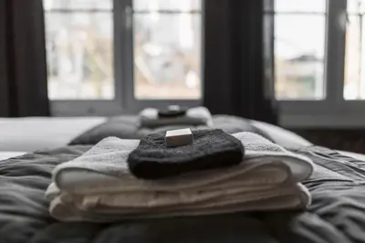 a pile of towels sitting on top of a bed at Lux Loft in the heart of Historic Antwerp in Antwerp