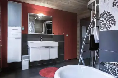 a bathroom with a white sink and a red wall at Lux Loft in the heart of Historic Antwerp in Antwerp