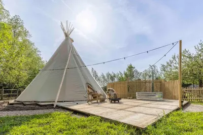 a teepee tent sitting on a wooden deck at Tipi Bo exclusief in Kaprijke