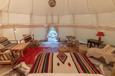 a room with a tent with chairs and a table at Tipi Bo exclusief in Kaprijke