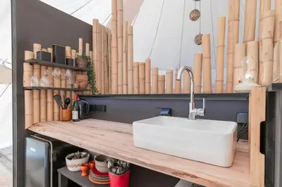 a kitchen with a sink on a wooden counter at Tipi Bo exclusief in Kaprijke