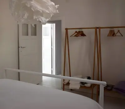 a white bedroom with a bed and a mirror at Peaceful retreat in Brussels