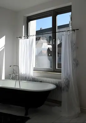 a bathroom with a bath tub and a window at Peaceful retreat in Brussels