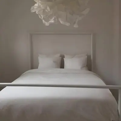 a white bed with white sheets and pillows at Peaceful retreat in Brussels