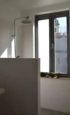 a kitchen with a refrigerator and a window at Peaceful retreat in Brussels