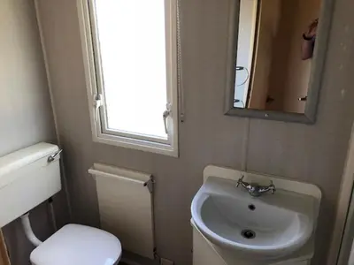 a bathroom with a sink and a toilet and a mirror at Verblijfpark De Brem in Lille
