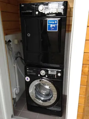a washer and dryer in a bathroom with a microwave at Verblijfpark De Brem in Lille