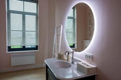 a bathroom with a sink and a mirror at Logies La Mairie in Waterland-Oudeman