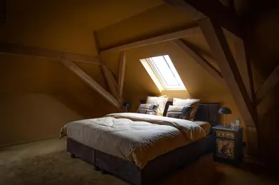a bedroom with a bed in an attic at Logies La Mairie in Waterland-Oudeman
