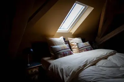 a bedroom with a bed with a window above it at Logies La Mairie in Waterland-Oudeman