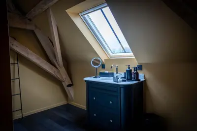 a bathroom with a vanity with a mirror and a window at Logies La Mairie in Waterland-Oudeman