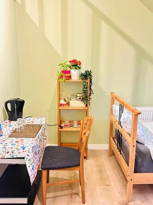 a room with a table and a bed and a table and chairs at The Nest In Leuven - Family Friendly Room in Leuven