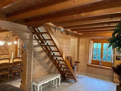 a wooden staircase in a room with a table at De Reinakker Bungalow in Sint-Gillis-Waas