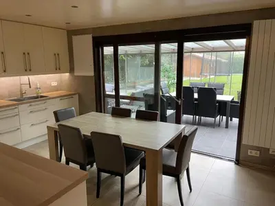 a kitchen and dining room with a table and chairs at De Reinakker Bungalow in Sint-Gillis-Waas