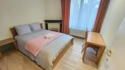 a small bedroom with a bed with a pink blanket at Bourse Grand Place in Brussels