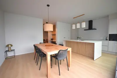a kitchen and dining room with a wooden table and chairs at YOURhouse in Geel