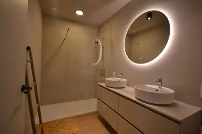 a bathroom with two sinks and a shower and a mirror at YOURhouse in Geel