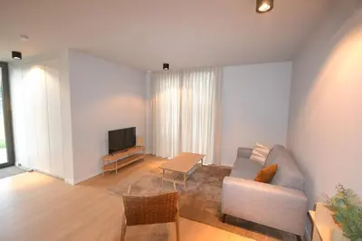 a living room with a couch and a tv at YOURhouse in Geel