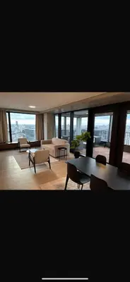 a living room with tables and chairs and windows at Luxurious apartment in city center in Brussels