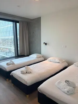 three beds in a room with a large window at Luxurious apartment in city center in Brussels