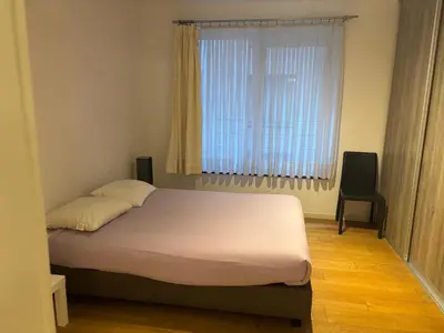 a bed in a room with a large window at Appartement 3chambres en plein centre-ville in Brussels