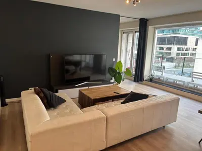 a living room with a white couch and a tv at Appartement 3chambres en plein centre-ville in Brussels
