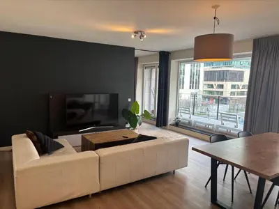 a living room with a white couch and a tv at Appartement 3chambres en plein centre-ville in Brussels